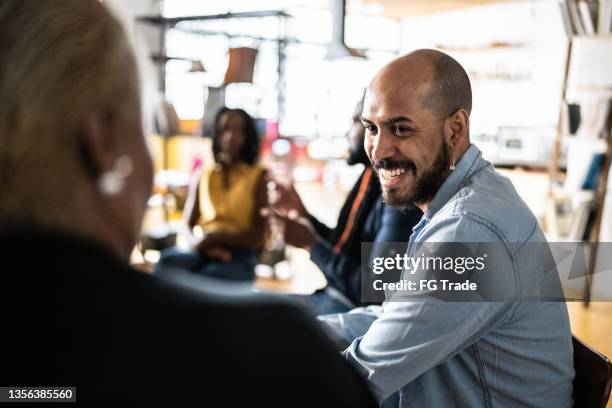 coworkers talking on a meeting - small business real people stock pictures, royalty-free photos & images