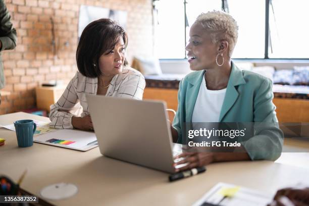 geschäftsfrauen, die ein meeting mit einem laptop im büro durchführen - small business meeting in asia stock-fotos und bilder