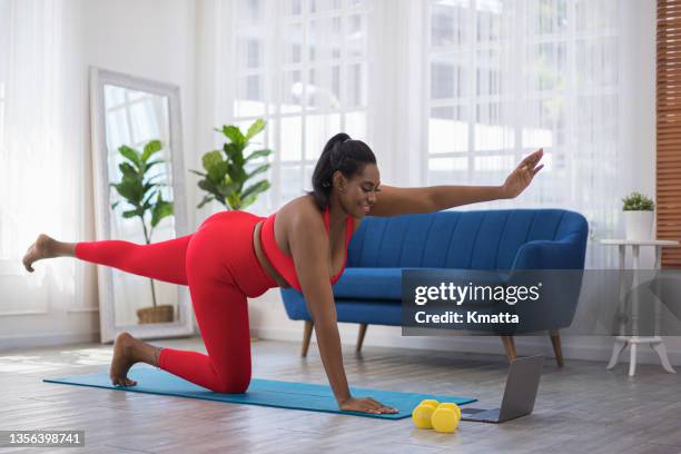 an attractive woman lying on floor practicing yoga routine at home. - the twist stock pictures, royalty-free photos & images