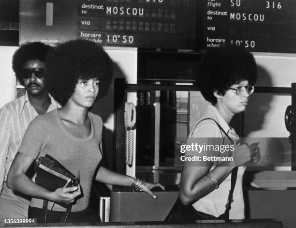 American Communist Angela Davis is accompanied by her sister, Fania, and traveling companion Frank Alexander on arrival at Orly Airport for a brief...