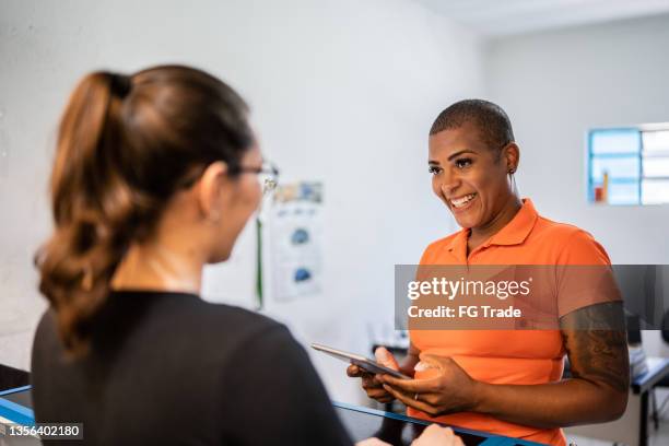 saleswoman talking to customer in a auto repair shop - auto mechanic shop stock pictures, royalty-free photos & images