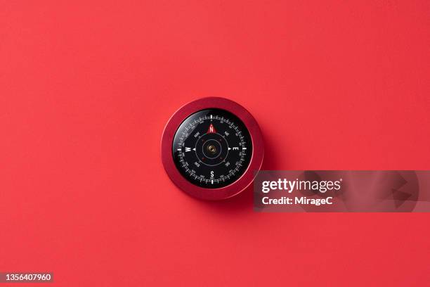 navigational compass on red background - compass north foto e immagini stock