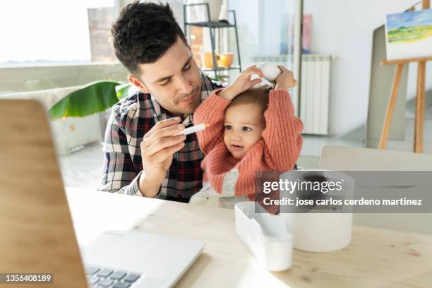 father giving the syrup to baby, girl does not want - hand over mouth stock pictures, royalty-free photos & images