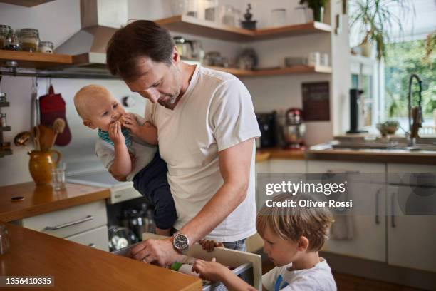 father with two sons in kitchen at home - één ouder stockfoto's en -beelden