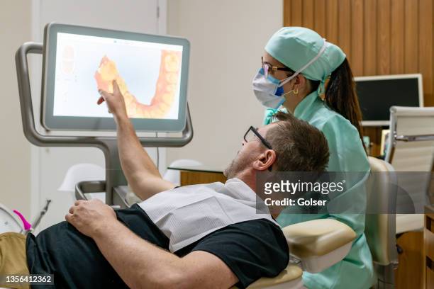 patient showing the dentist the need for intervention on his teeth - 3d scanning stock pictures, royalty-free photos & images