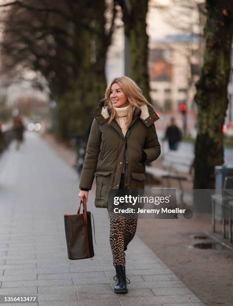 Yasmin von Schlieffen-Nannen wearing olive Mackage parka, beige Isabel Marant knit sweater, Ganni Leo Print leggings, brown Yves Saint Laurent...