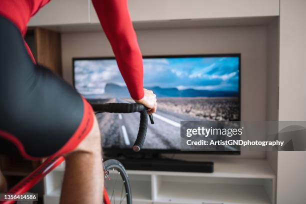 nahaufnahme der hand eines mannes, der zu hause fahrrad fährt - heimtrainer stock-fotos und bilder