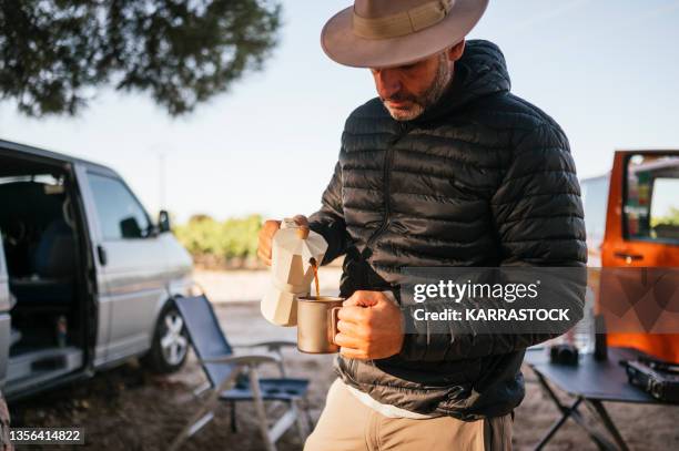 camping man helping himself to coffee in the woods. - provincie guadalajara stockfoto's en -beelden