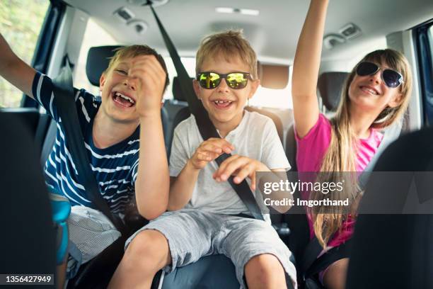 brothers and sisters enjoying travelling by car - kids inside car stock pictures, royalty-free photos & images