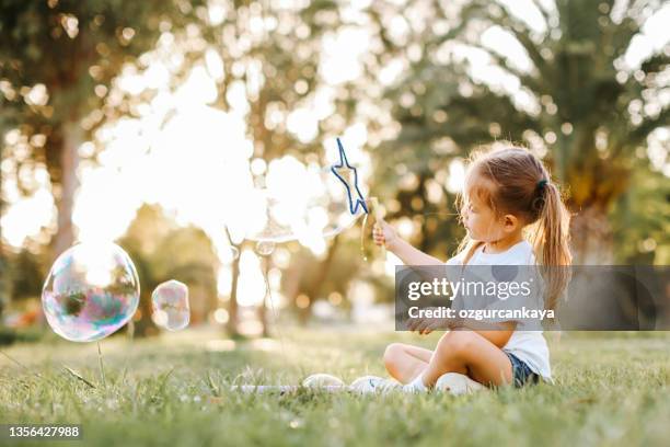 happy little girl running in the nature - bubbles happy stockfoto's en -beelden