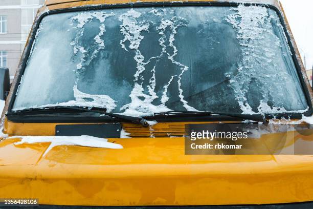 frosty patterns on a completely ice covered car windscreen - schneeregen stock-fotos und bilder