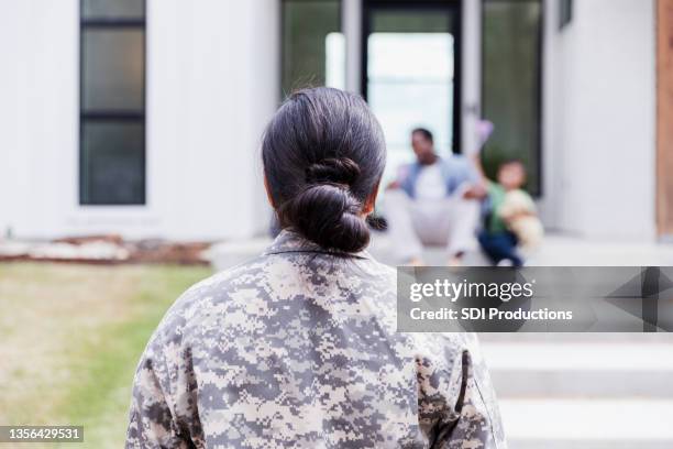 une femme soldat rentre chez elle - back porch designs photos et images de collection