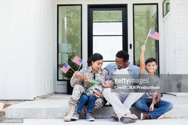 female soldier is excited to be home with her family - armed forces stock pictures, royalty-free photos & images