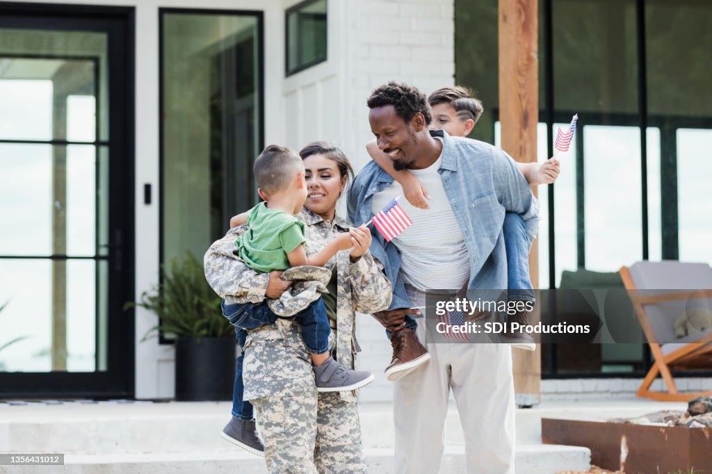 Family carries flags to celebrate soldier mom's homecoming
