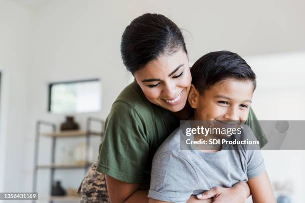 兵士のお母さんは、プレティーン息子大きな抱擁を与えます - 8歳から9歳 ストックフォトと画像