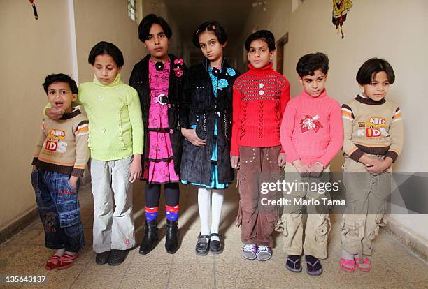 Orphans who lost parents in war-related violence Lubna Qais, Suha Qais, Nabaa Qais, Randa Monam, Marwa Hassan, Warud Walid and Doha Qais stand in the...