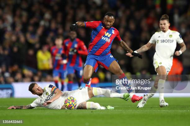 Jordan Ayew of Crystal Palace is challenged by Liam Cooper of Leeds United during the Premier League match between Leeds United and Crystal Palace at...