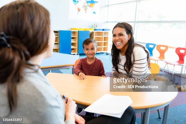 cute boy watches mom and teacher in meeting - teachers imagens e fotografias de stock