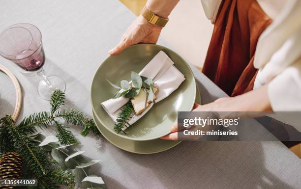 christmas celebration: an anonymous woman setting up christmas dinner table - christmas party host stock pictures, royalty-free photos & images