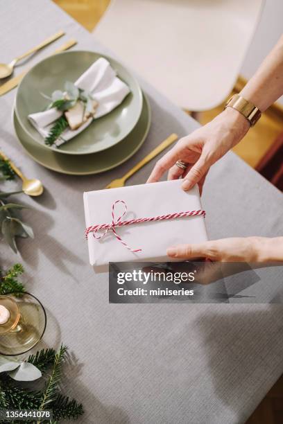 christmas celebration: an anonymous woman setting up christmas dinner table - party host stock pictures, royalty-free photos & images