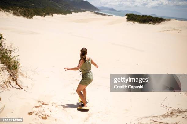 woman sliding on sandboard - sandboarding stock pictures, royalty-free photos & images