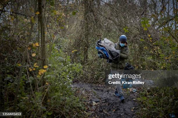 Migrant leaves a makeshift camp on the outskirts of Calais as Police evict migrants in an attempt to disperse migrants from gathering along the...