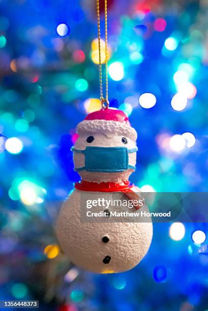 Decorative Christmas snowman with a blue surgical face mask hangs on a Christmas tree on November 30 in Cardiff, Wales. Coronavirus restrictions have...