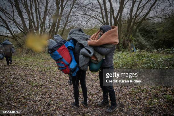 Migrants leave the Grande-Synthe migrant camp with whatever possessions they can carry after being evicted as police break up the camp in the latest...