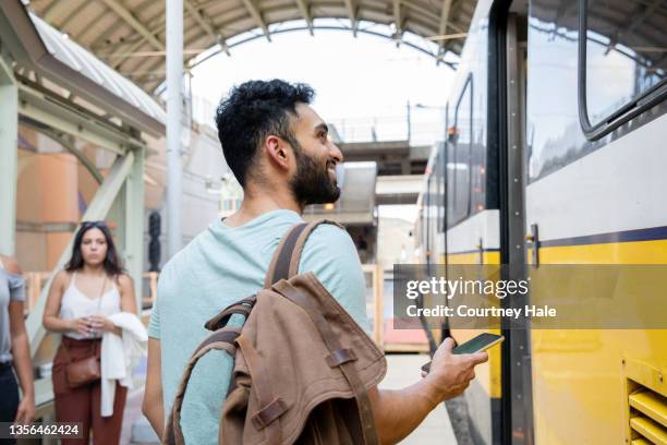 young man standing on train station platform - indian arrival stock pictures, royalty-free photos & images