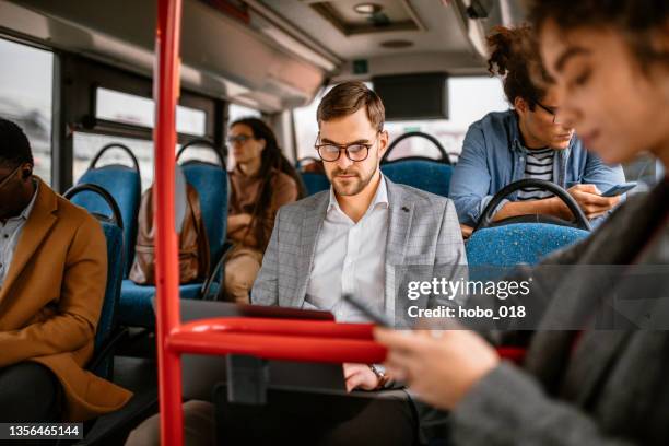 geschäftsmann mit öffentlichen verkehrsmitteln auf dem weg ins büro - laptop on bus stock-fotos und bilder