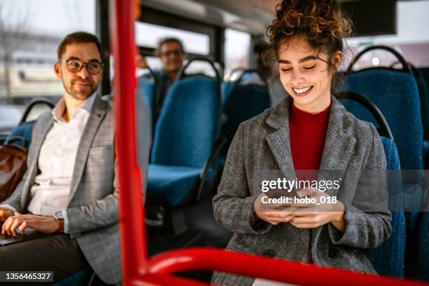 lächelnde frau am telefon während der fahrt mit dem bus - laptop on bus stock-fotos und bilder