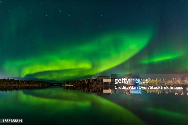 aurora reflected in the calm waters of frame lake, canada. - yellowknife canada stockfoto's en -beelden