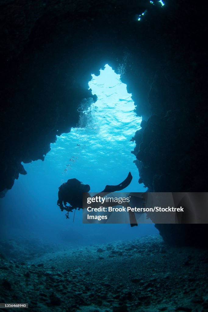 A diver exiting a swim through cavern, Kadavu Island, Fiji.