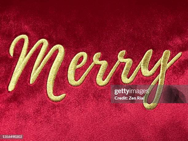 the word merry embroidered on red fabric - embroidery stockfoto's en -beelden