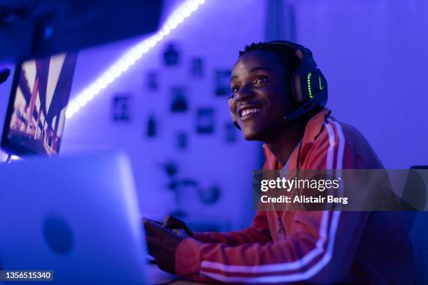 young male gamer playing at night - africa game stock pictures, royalty-free photos & images