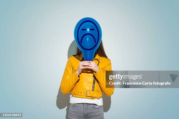 woman covering face with blue balloon with - tempio pausania fotografías e imágenes de stock