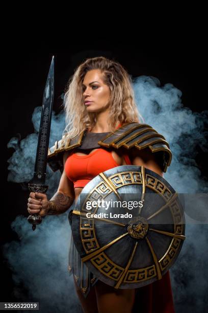 a female warrior gladiator holding a weapon - romeinse rijk stockfoto's en -beelden