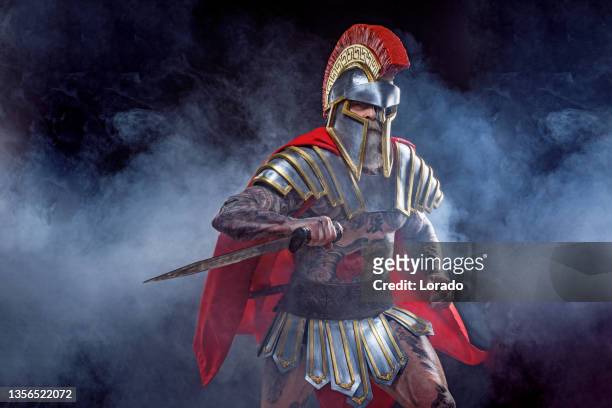 a senior bearded warrior gladiator holding a weapon - gladiator armour stock pictures, royalty-free photos & images
