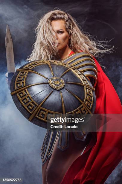 una mujer gladiadora guerrera sosteniendo un arma - soldados romanos fotografías e imágenes de stock