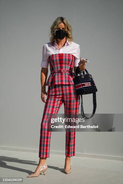 Guest wears gold chain pendant necklaces from Dior, a pale pink short sleeves shirt, a red and black checkered print pattern shoulder-off belted top...