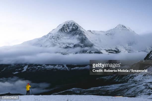 person photographing the snowcapped eiger in mist, switzerland - grindelwald stock pictures, royalty-free photos & images