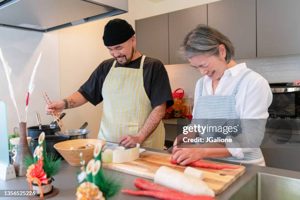 senior woman and her adult son preparing food together - winter cooking stock pictures, royalty-free photos & images