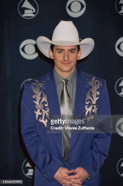American singer and songwriter Brad Paisley, wearing a blue jacket over a grey shirt with a silver tie and a white cowboy hat, attends the 42nd...