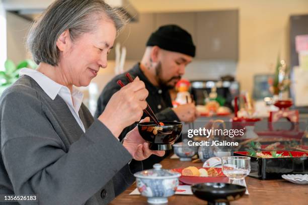 senior japanese woman enjoying ozoni soup - 御節料理 個照片及圖片檔