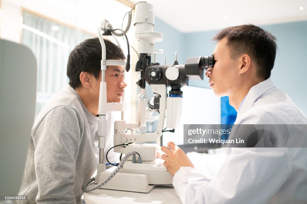 The ophthalmologist is examining the eyes of the patient