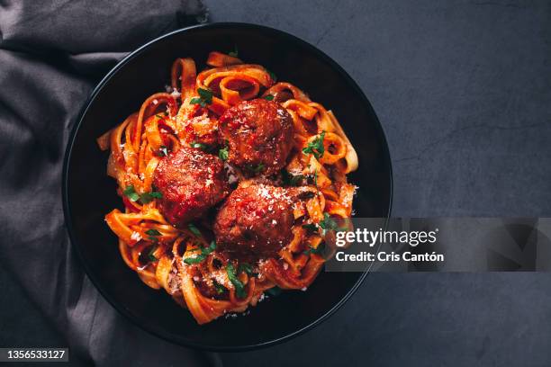 tagliatelle  with meatballs and  tomato sauce on black background. - meatball imagens e fotografias de stock