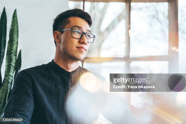 portrait of a young handsome asian entrepreneur, smiling and looking forward to the future innovations - escritório tecnologia olhar em frente imagens e fotografias de stock