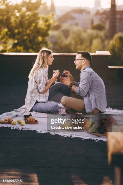 glückliches paar, das sich beim picknick auf einer terrasse unterhält. - paar picknick stock-fotos und bilder