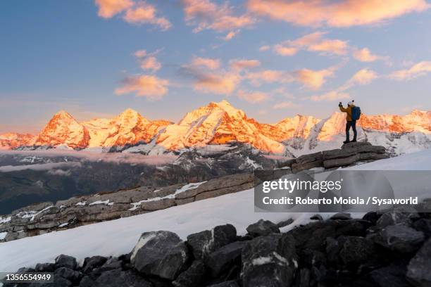 person photographing mount eiger at sunset, switzerland - eiger mönch jungfrau stockfoto's en -beelden