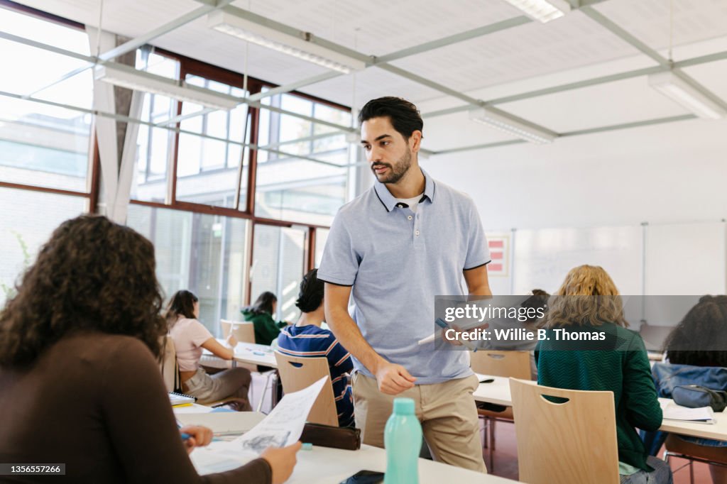 Teacher Handing Tests Out To Pupils